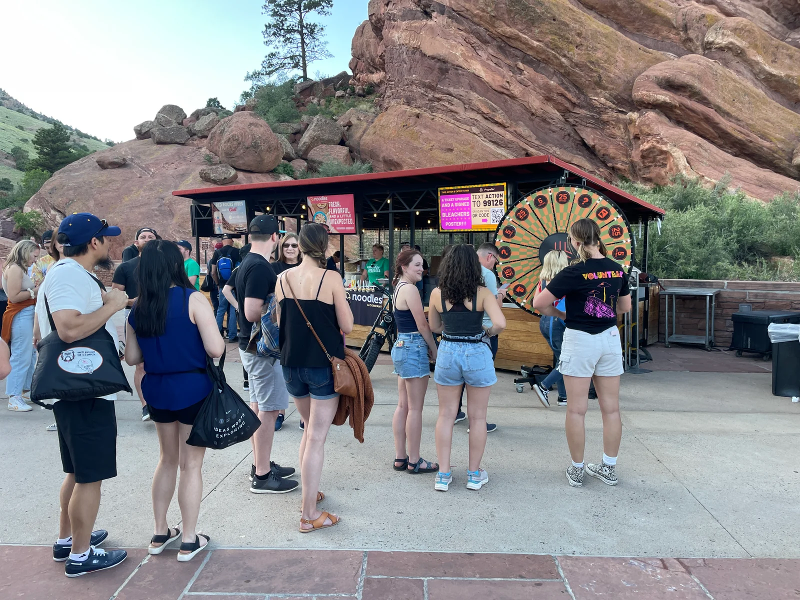 Fans taking part in a Propeller activation beside our prize wheel and campaign sign at Red Rocks